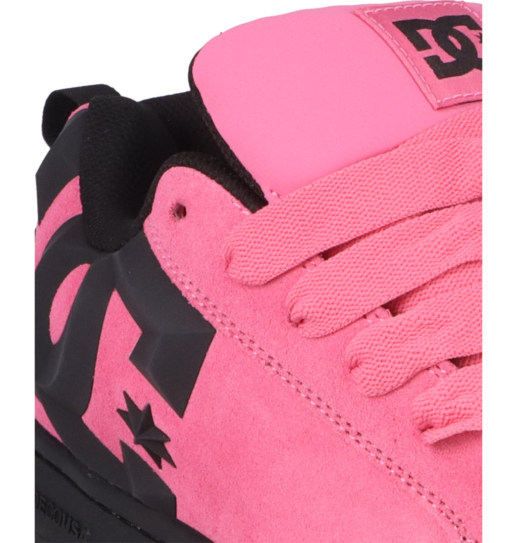 Close-up of the Men’s Court Graffik Beveled Special Edition Shoes by DC Shoes, showcasing a pink colorway with black accents, pink laces, and prominent black DC branding on the side. The sneaker features suede material, a signature puffy silhouette inspired by the Court Graffik Beveled collection, and a padded tongue adorned with branding.