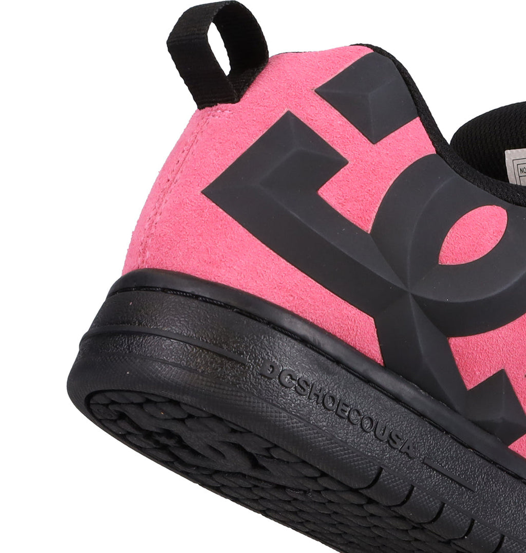 A close-up of the heel of a pink and black Men’s Court Graffik Beveled Special Edition Shoe by DC Shoes, featuring the iconic DC logo and “DCSHOECOUSA” embossing on the black sole, highlighting its signature puffy silhouette and bold DC branding.