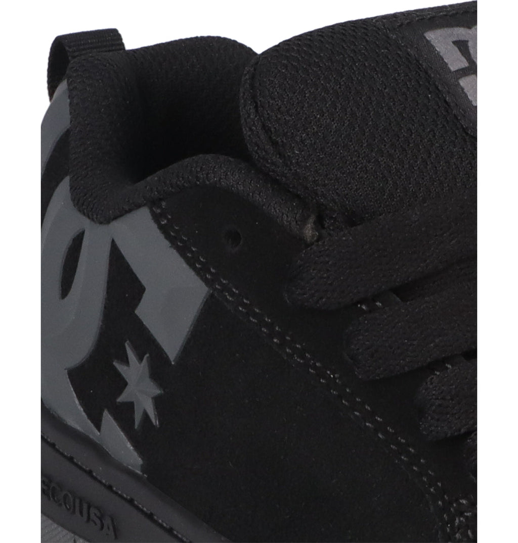 Close-up of the Kids’ Court Graffik Beveled Special Edition Shoes by DC Shoes in black, featuring a prominent gray beveled DC logo and star design on the side for bold branding. The signature puffy silhouette is clearly visible, complemented by black laces and tongue, with part of the sole also shown.