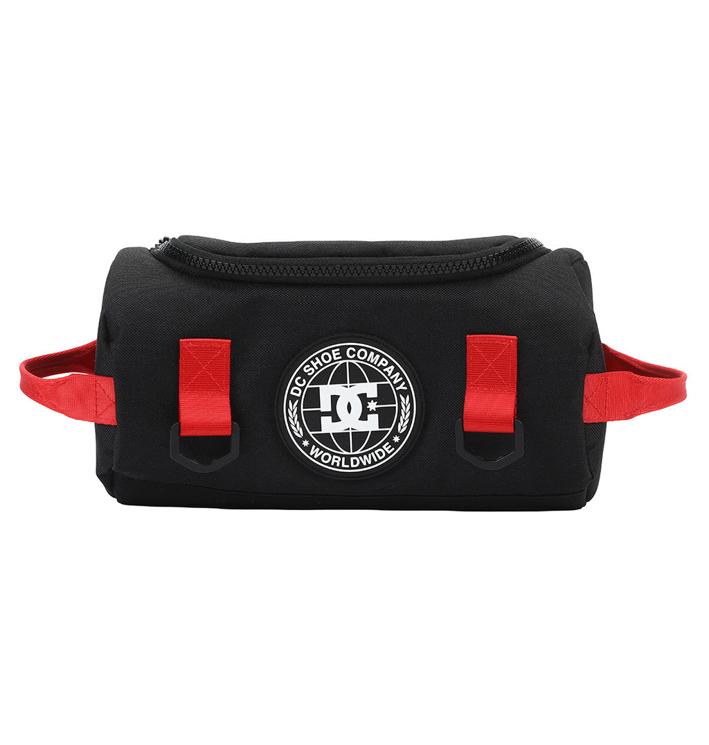 The DC Shoes DC Runner Dopp Kit is a black zippered pouch with red side handles and loops, featuring a round white DC Shoe Company Worldwide logo on the front.