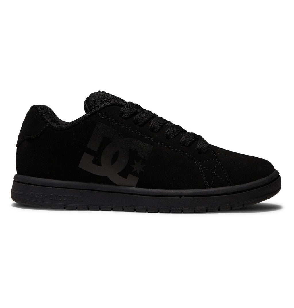 A pair of Kids’ Gaveler Shoes by DC Shoes is shown in side profile on a white background, featuring a classic design with a durable black leather upper, black sole, matching black laces, and a bold black DC logo on the side.