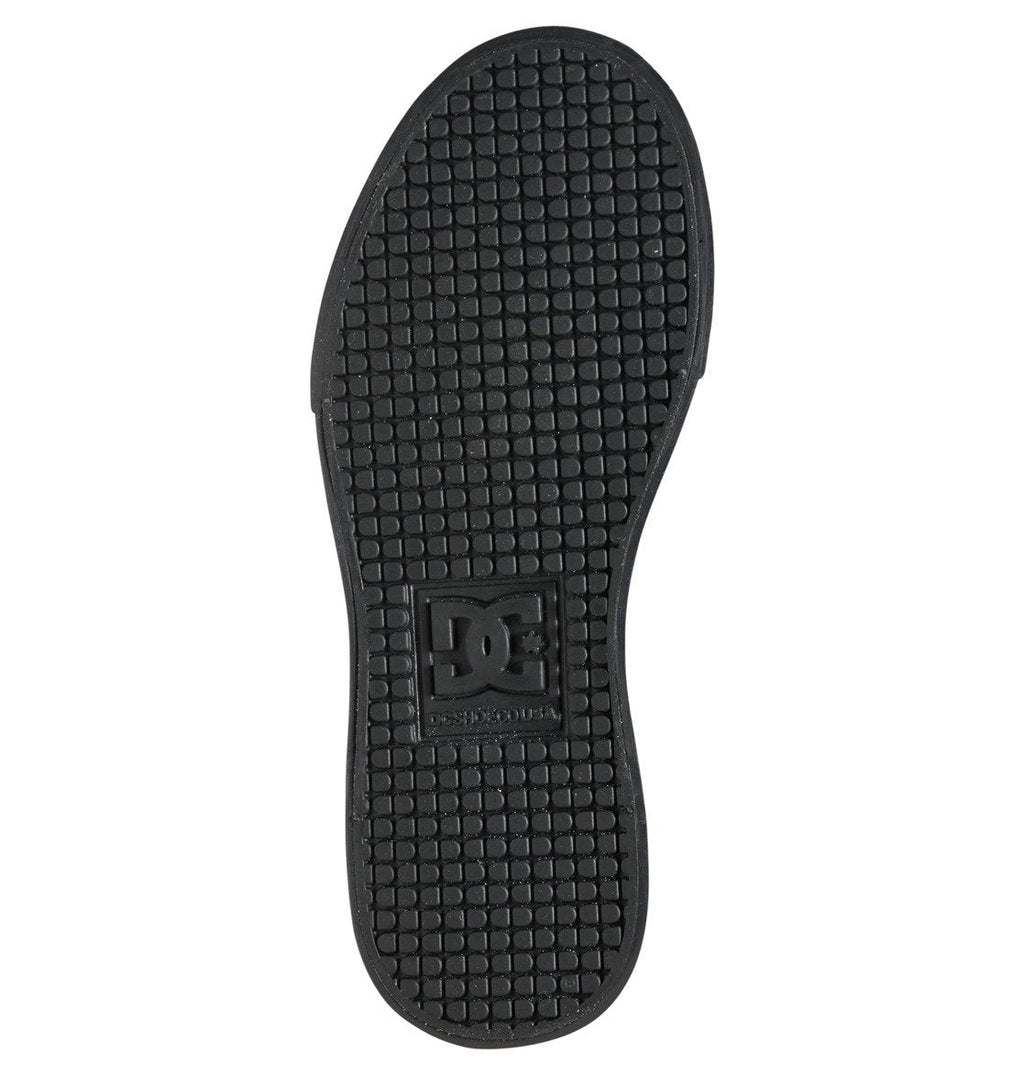 Rubber sole of the DC Shoes Kids’ Pure High Elastic Lace High-Top Shoes featuring a black, grid-textured tread and a raised rectangular section with the DC Shoes logo at the center. Designed for kids’ high-top sneakers, this durable sole is shown from the bottom view.