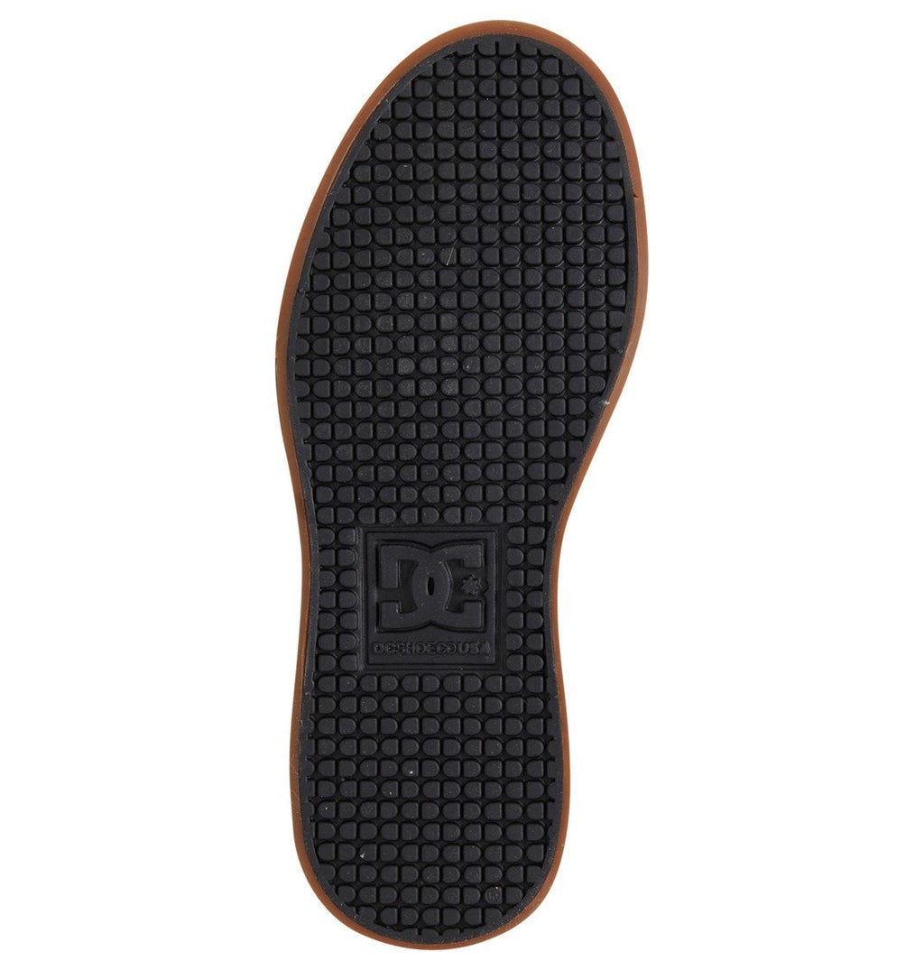 The Kids’ Pure High Elastic Lace High-Top Shoes by DC Shoes feature a black rubber sole with a tan border, showcasing a textured grid pattern and a prominent DC logo at the center. Designed for kids’ skate shoes or kids’ high-top sneakers, the sole looks brand new and unworn, displayed against a white background.