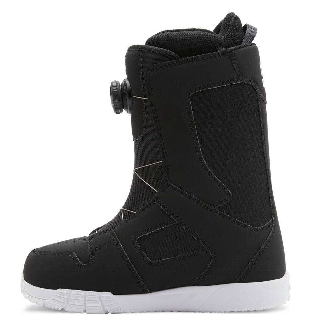 A side view of the DC Shoes Women’s Phase BOA® Snowboard Boot in black with a white sole, showcasing the BOA Fit System dial closure on the side and geometric stitching details.