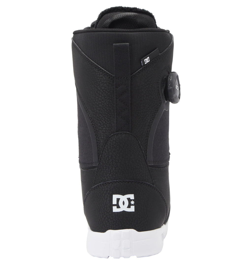 A rear view of the DC Shoes Women’s Lotus BOA® Snowboard Boot in black, featuring a white UNILITE outsole. The heel displays the DC Shoes logo, and a round Dual Zone BOA® Fit System adjustment dial is visible on the side.