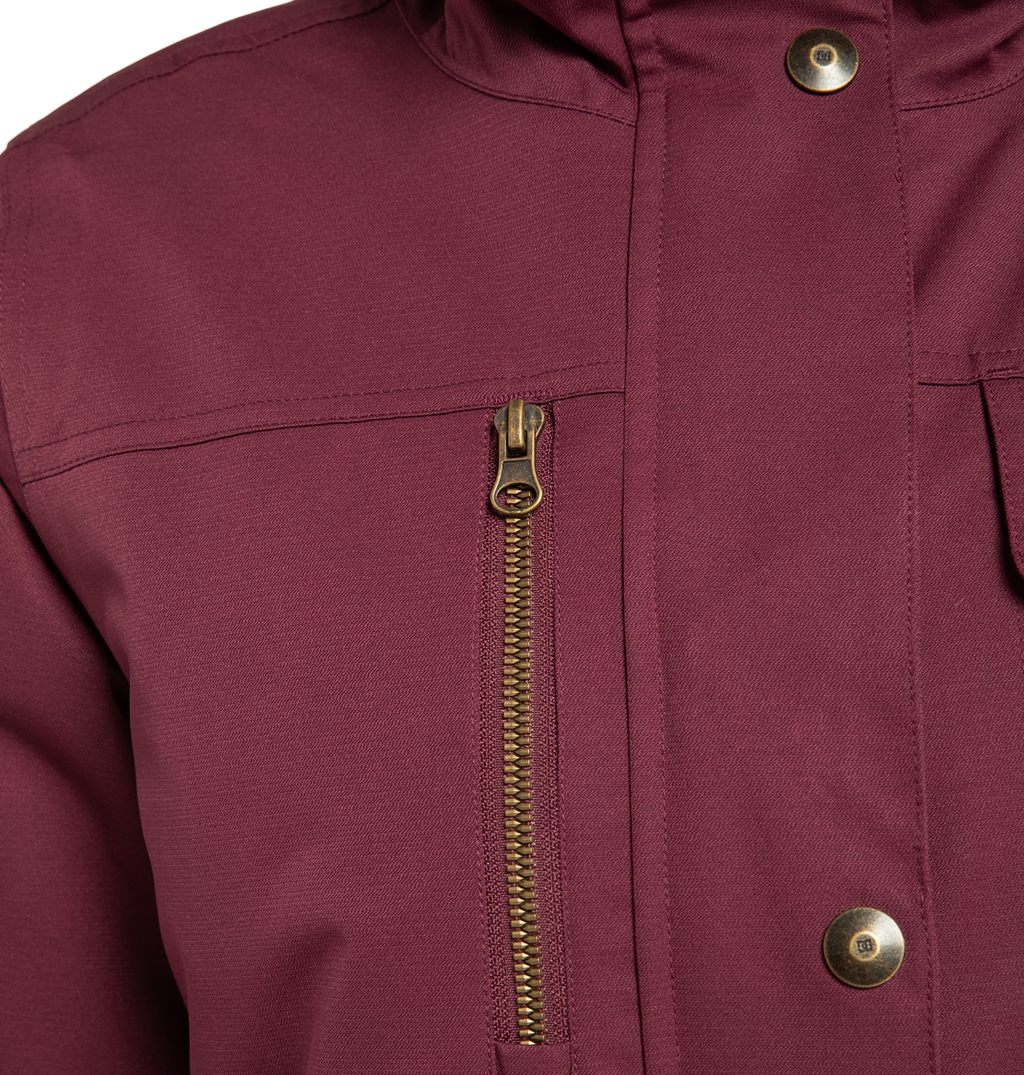 Close-up of the DC Shoes Women’s Liberate Insulated Jacket in maroon, featuring brass snap buttons and a vertical zippered chest pocket. Detailed stitching and textured fabric offer superior weather defense—ideal for your next winter adventure.