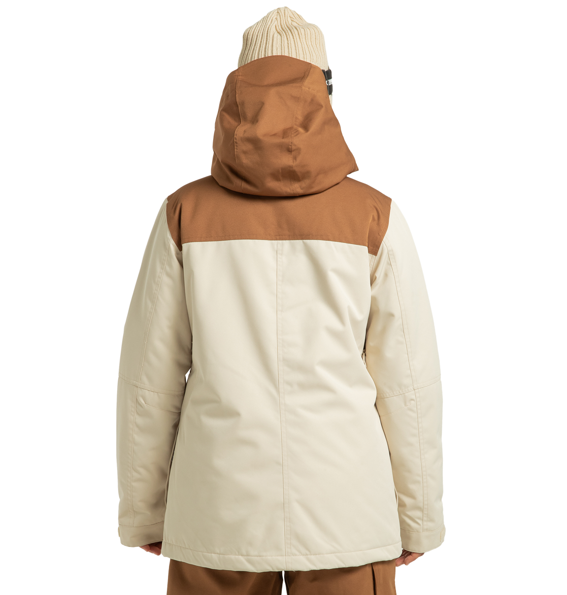 A person wearing the DC Shoes Women’s Liberate Insulated Jacket—a beige and brown hooded winter jacket constructed from recycled polyester—paired with a beige knit beanie is shown from the back, standing against a plain white background.