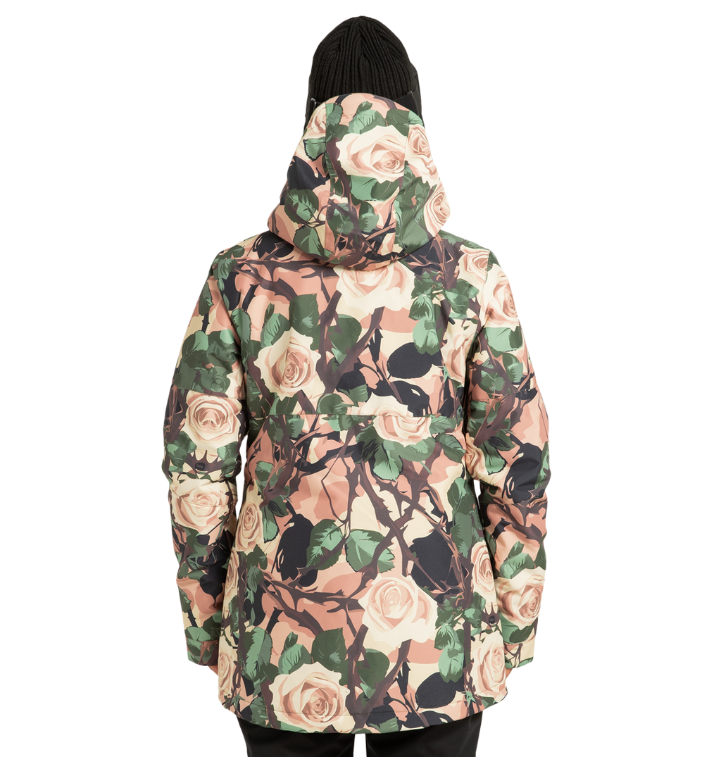 A person wearing the DC Shoes Women’s Cruiser Insulated Snow Jacket, featuring a floral pattern and made from recycled polyester, along with a black knit beanie, faces away from the camera against a plain white background.
