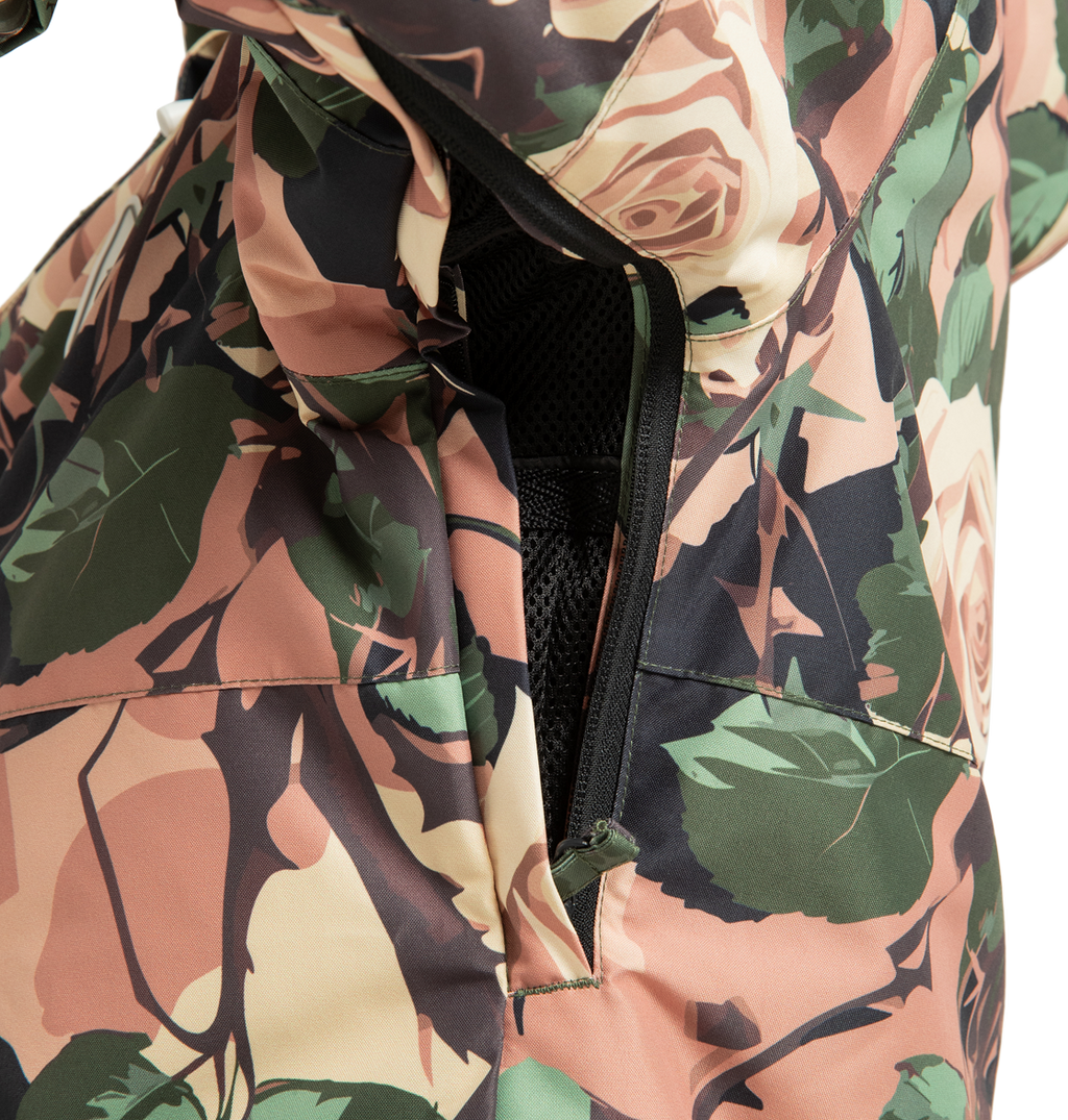 A close-up of the DC Shoes Women’s Cruiser Insulated Snow Jacket displays an unzipped vent lined with black mesh fabric, revealing part of the insulated interior made from recycled polyester.