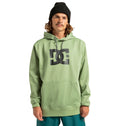 A person wearing a light green DC Shoes Unisex Snowstar Hoodie, teal pants, and a black knit beanie stands facing forward with hands by their sides against a white background. This weather-defense polyester hoodie from DC Shoes combines comfort and style for any occasion.