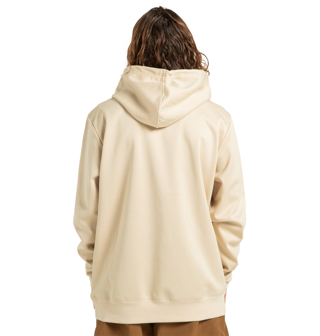 A person with long, wavy brown hair is shown from the back against a white background, wearing a light beige DC Shoes Unisex Snowstar Hoodie made from polyester bonded fleece and paired with brown pants. The hoodie by DC Shoes provides reliable weather protection while ensuring both style and comfort.