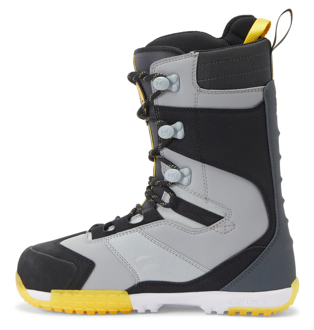 The DC Shoes Men’s Premier Hybrid BOA® Snowboard Boots are shown in a side profile view against a white background, featuring a gray and black design with yellow accents, black laces, a rugged yellow sole, and the advanced BOA® Fit System.