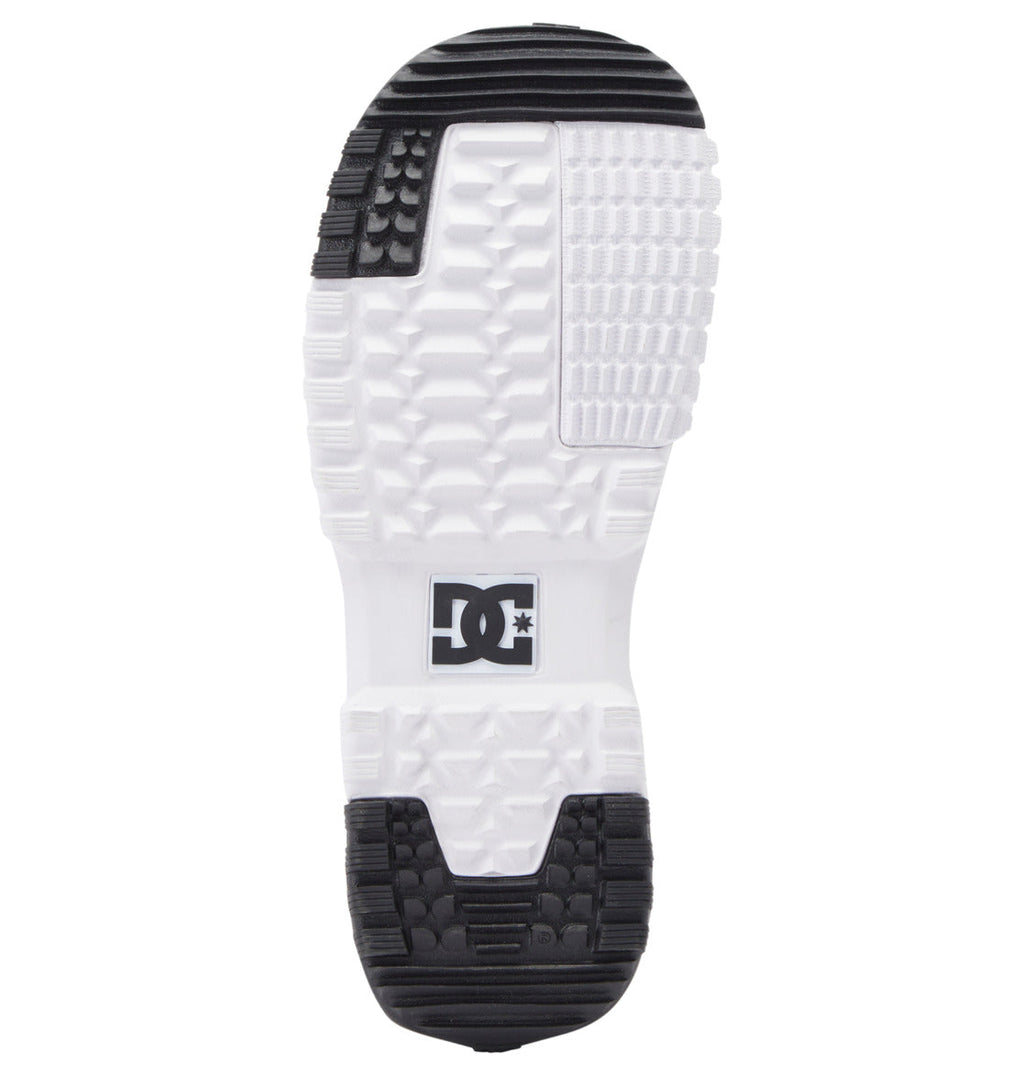 Bottom view of the DC Shoes Men’s Control BOA® Snowboard Boot sole, featuring white textured rubber with black grip pads at the heel and toe, and the DC logo embossed in the arch area—highlighting design elements inspired by classic skate footwear.