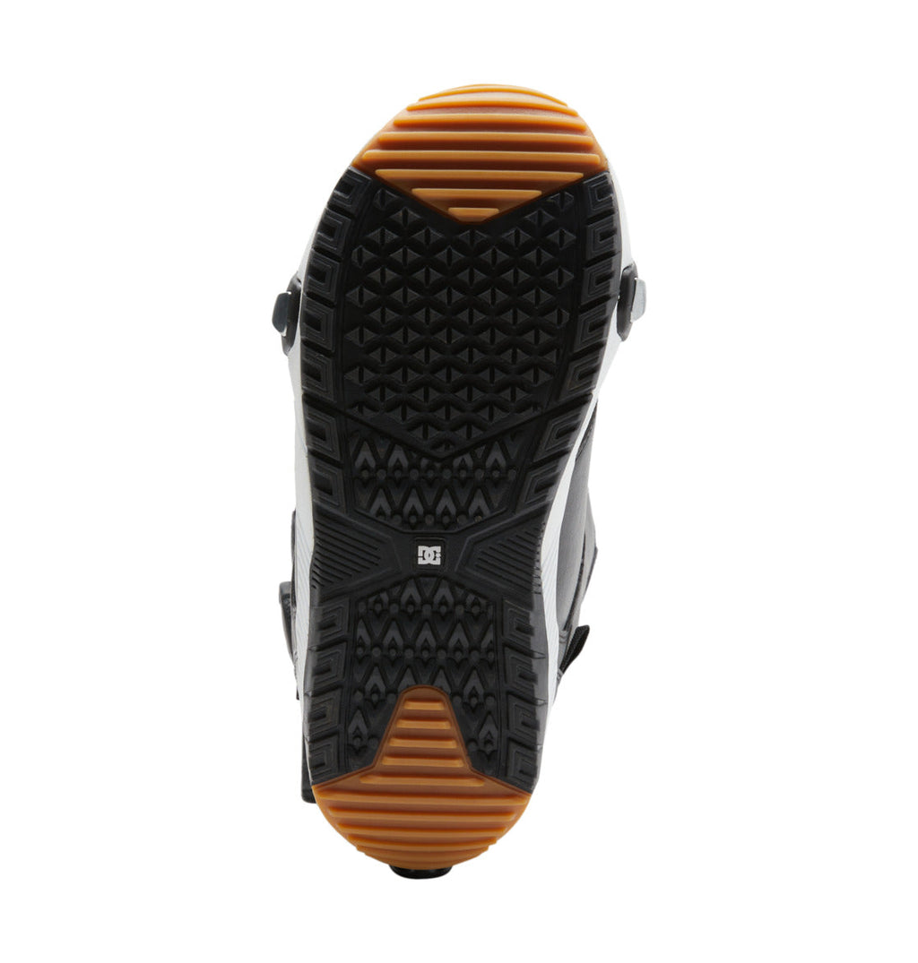 The sole of the Men’s Control Step On BOA® Snowboard Boot by DC Shoes features black and brown rubber tread with geometric patterns and a central DC Shoes logo, shown from the bottom against a white background.