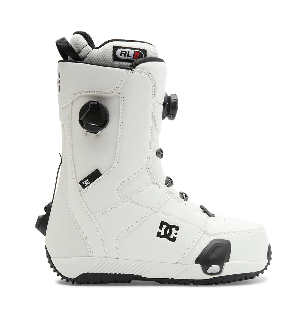 Introducing the Men’s Control Step On® Snowboard Boots by DC Shoes: These white boots feature black accents, a textured sole, and a side dial tightening system. Showcasing advanced snow boot technology, they come equipped with the Dual Zone BOA Fit System for customizable comfort and security. The signature DC Shoes logo appears near the ankle.