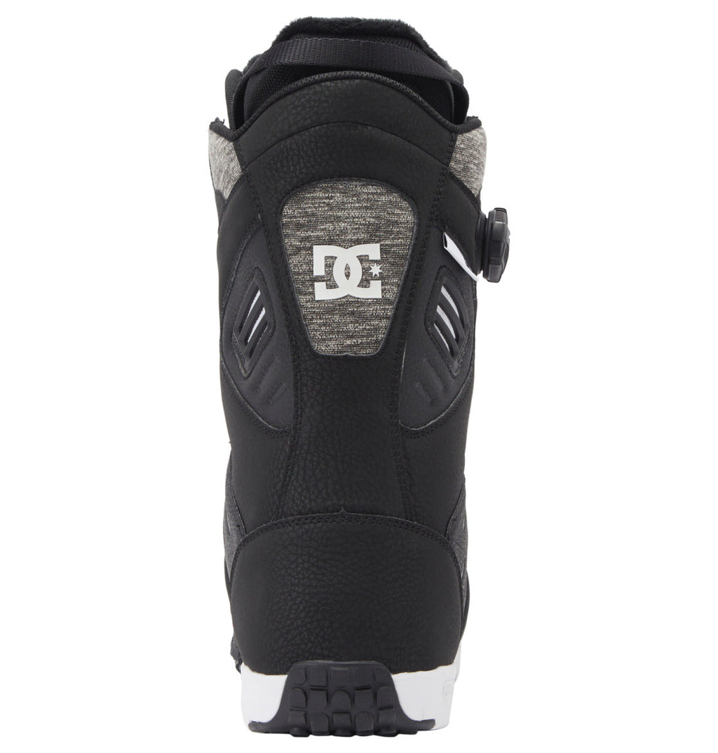 Back view of the Men’s Judge BOA® Snowboard Boots by DC Shoes, shown in black with gray fabric accents. These snowboarding boots feature a Dual Zone BOA® Fit System dial tightening mechanism on the side and display a white DC Shoes logo on the heel. The durable sole combines black and white detailing and is constructed with a Vibram outsole for enhanced grip.