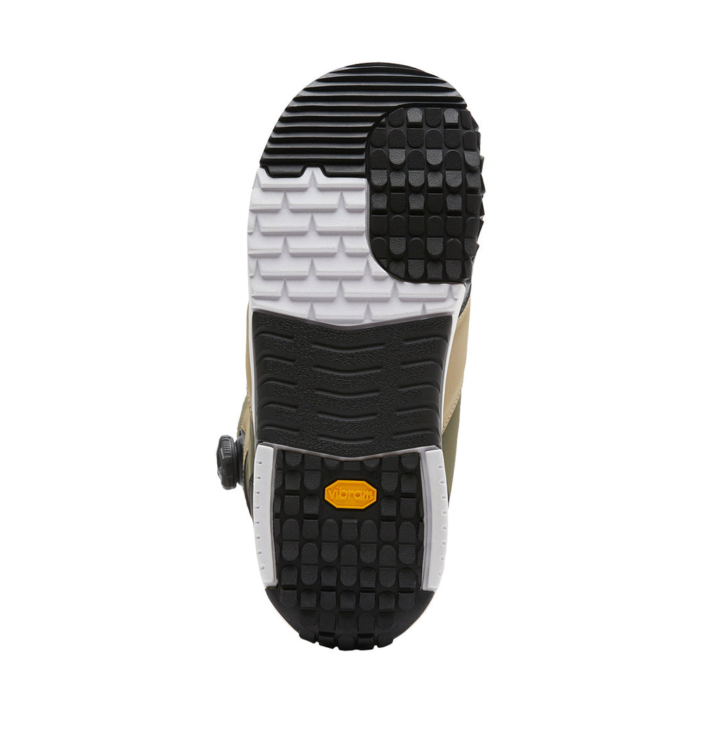 The image displays the sole of the Men’s Judge BOA® Snowboard Boots from DC Shoes, showcasing a combination of black, white, and tan rubber tread with distinct patterns and a central yellow Vibram logo. Engineered for durability and performance, these boots are equipped with the advanced BOA® Fit System to ensure a secure fit.