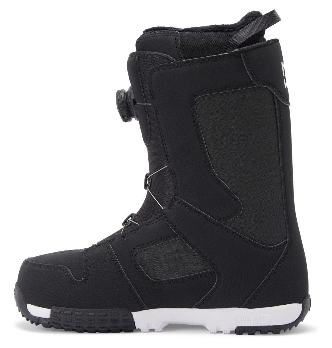 A black DC Shoes Men’s Phase Pro BOA® snowboard boot with textured material, a white sole, and a side dial lacing system. This boot features visible stitching, PrimaLoft insulation for added warmth, and a pull loop at the back.