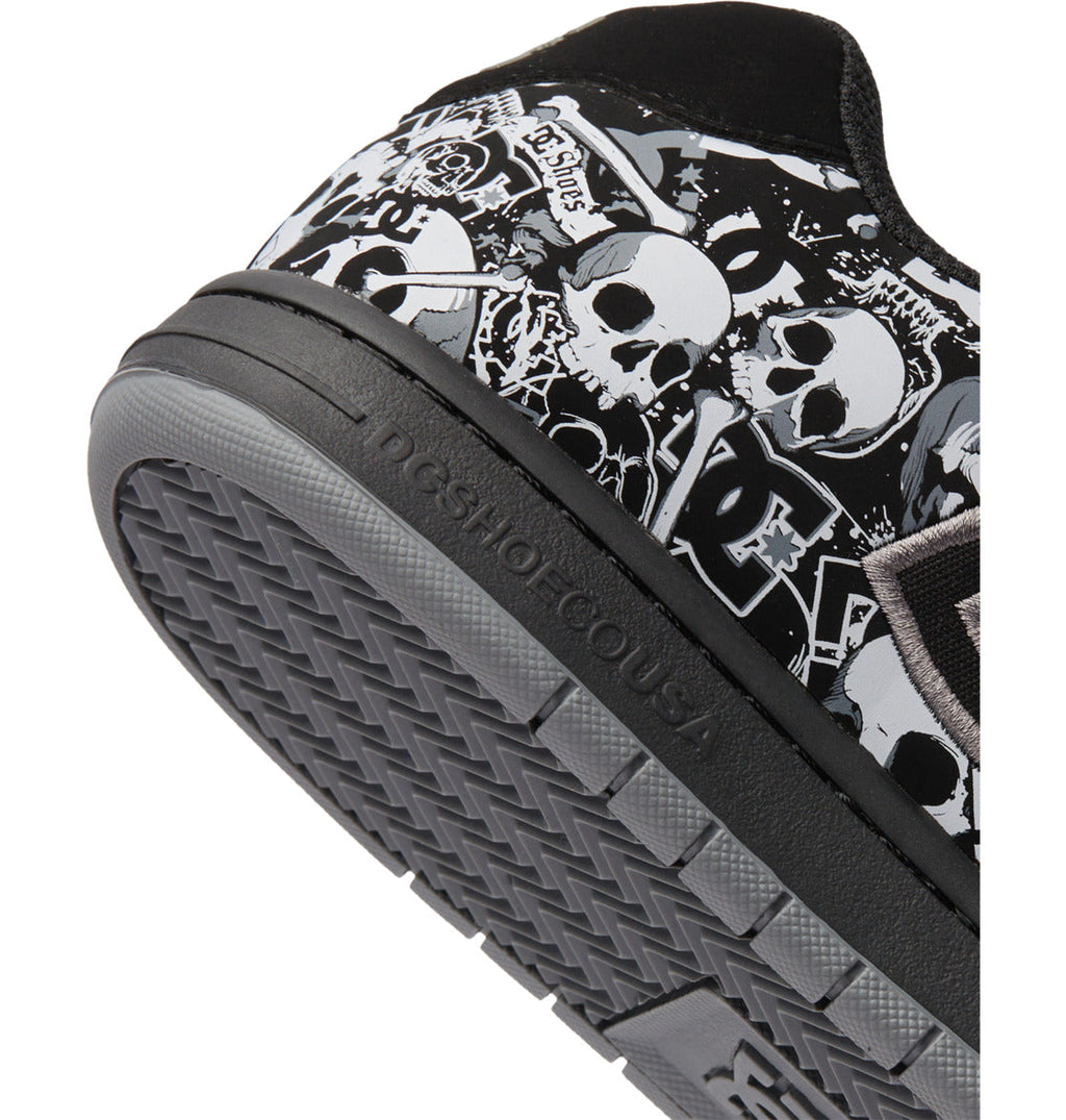 A close-up of the heel and sole of the Men’s Gaveler Shoes by DC Shoes showcases a black, white, and gray graffiti design with skulls and graphic elements. Constructed from durable leather for everyday wear, this model features a chunky silhouette. The textured sole displays the DC SHOES branding.