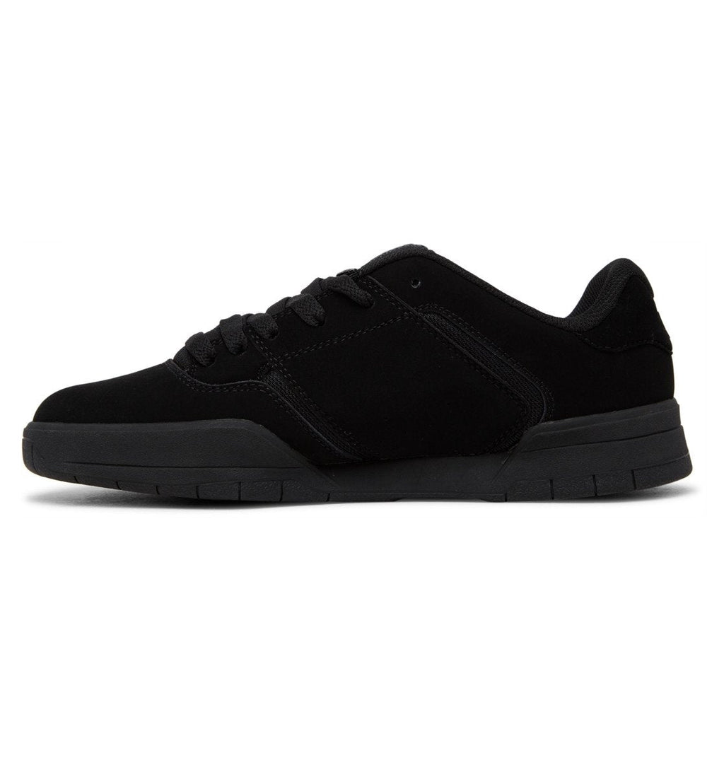 A side view of the Men’s Central Shoes by DC Shoes showcases a black, low-top sneaker with a flat cupsole and matching black laces. Featuring visible stitching details on the upper that emphasize its durability, this simple and unbranded design captures the classic DC style.
