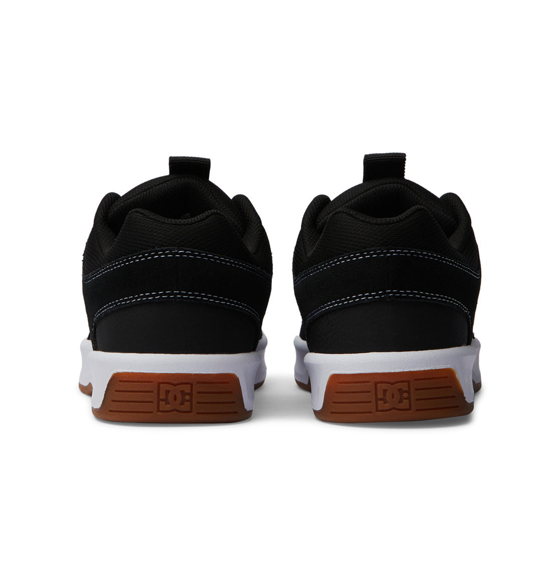 A pair of DC Shoes Men’s Lynx Zero sneakers in black, seen from the back, highlighting their brown rubber soles with the signature DC logo and clean white midsoles—a timeless skate shoe silhouette that marries classic design with contemporary style.