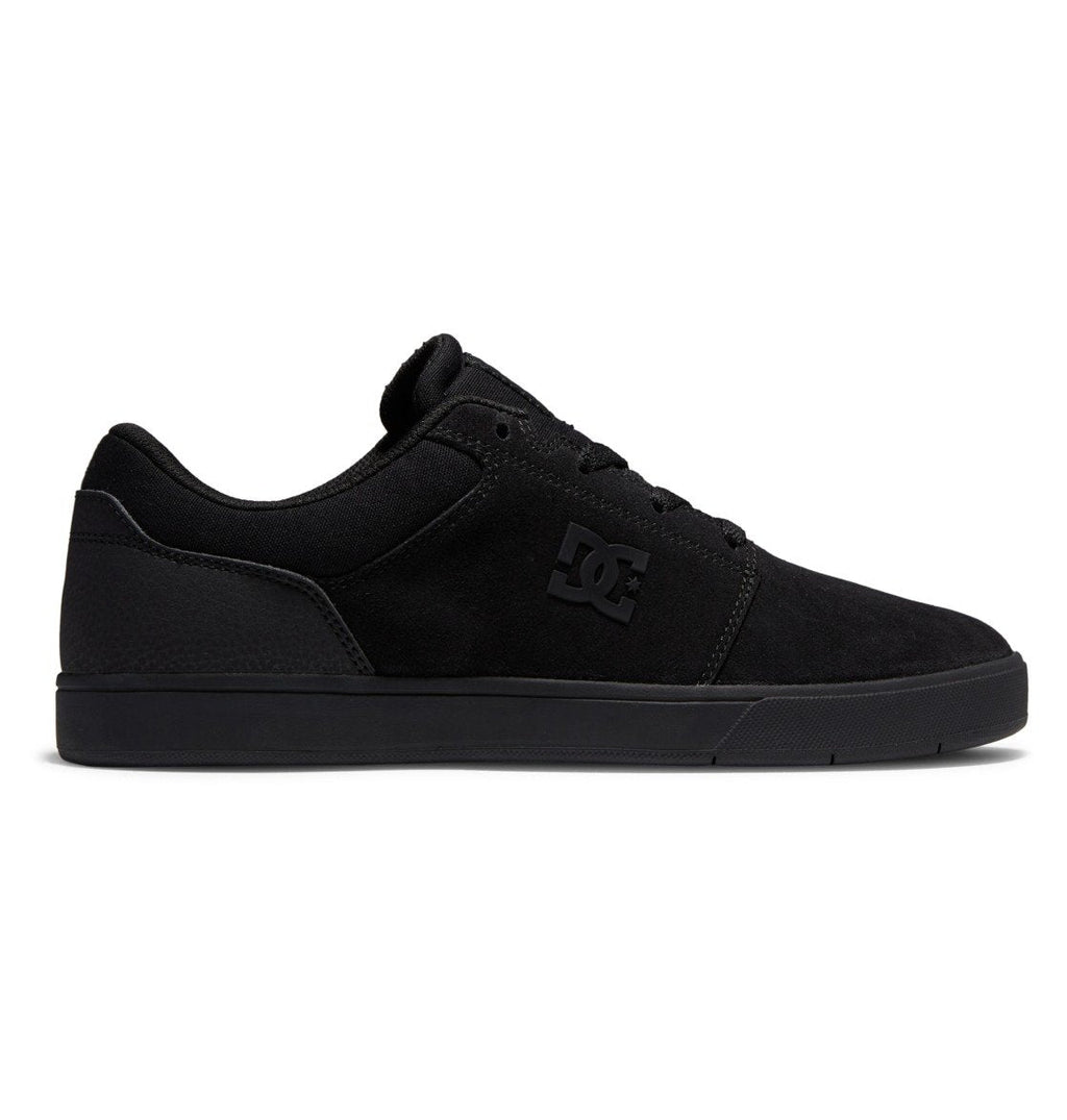 A side profile of the Men’s Crisis 2 Shoes by DC Shoes is shown in black, featuring a low-top silhouette, a performance cup sole, and subtle branding on the side, photographed against a white background.