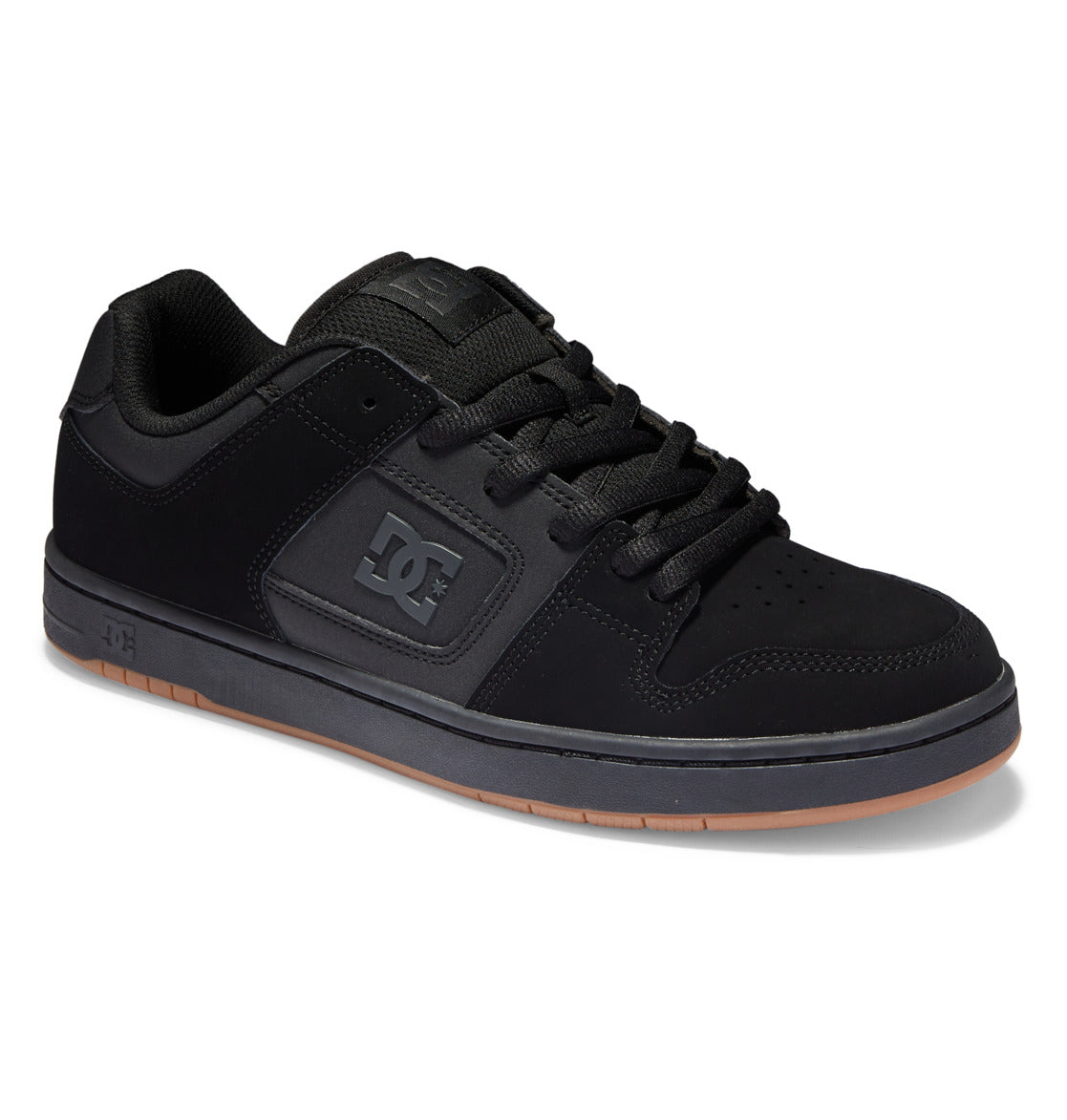 The Men’s Manteca 4 Shoes by DC Shoes feature a low-top design in black with matching black laces, complemented by a gray sole with a brown bottom. The DC logo appears on both the side and tongue, offering a classic skate style combined with modern comfort for everyday wear.