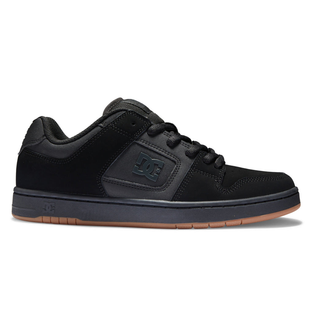 A pair of Men’s Manteca 4 Shoes by DC Shoes, featuring a black upper with a dark gray sole and gum accents, the signature DC logo on the side, and a padded tongue and collar for modern comfort.