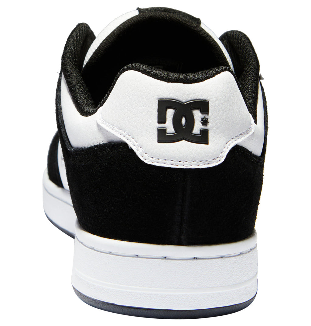 The Men’s Manteca 4 Shoes by DC Shoes are black and white skate shoes seen from the back, displaying the iconic DC Shoes logo on the heel. This model features a white midsole paired with a black outsole, combining classic style with modern comfort.
