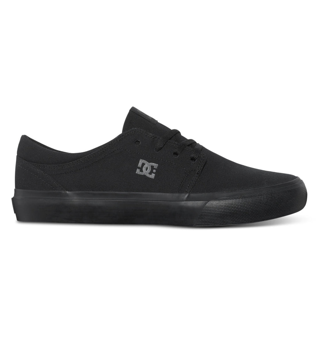 The DC Shoes Men’s Trase Canvas Shoes are black low-top skate shoes with a rubber sole and laces, featuring the signature DC Shoes logo on the side for that classic skate style in a low-profile design.
