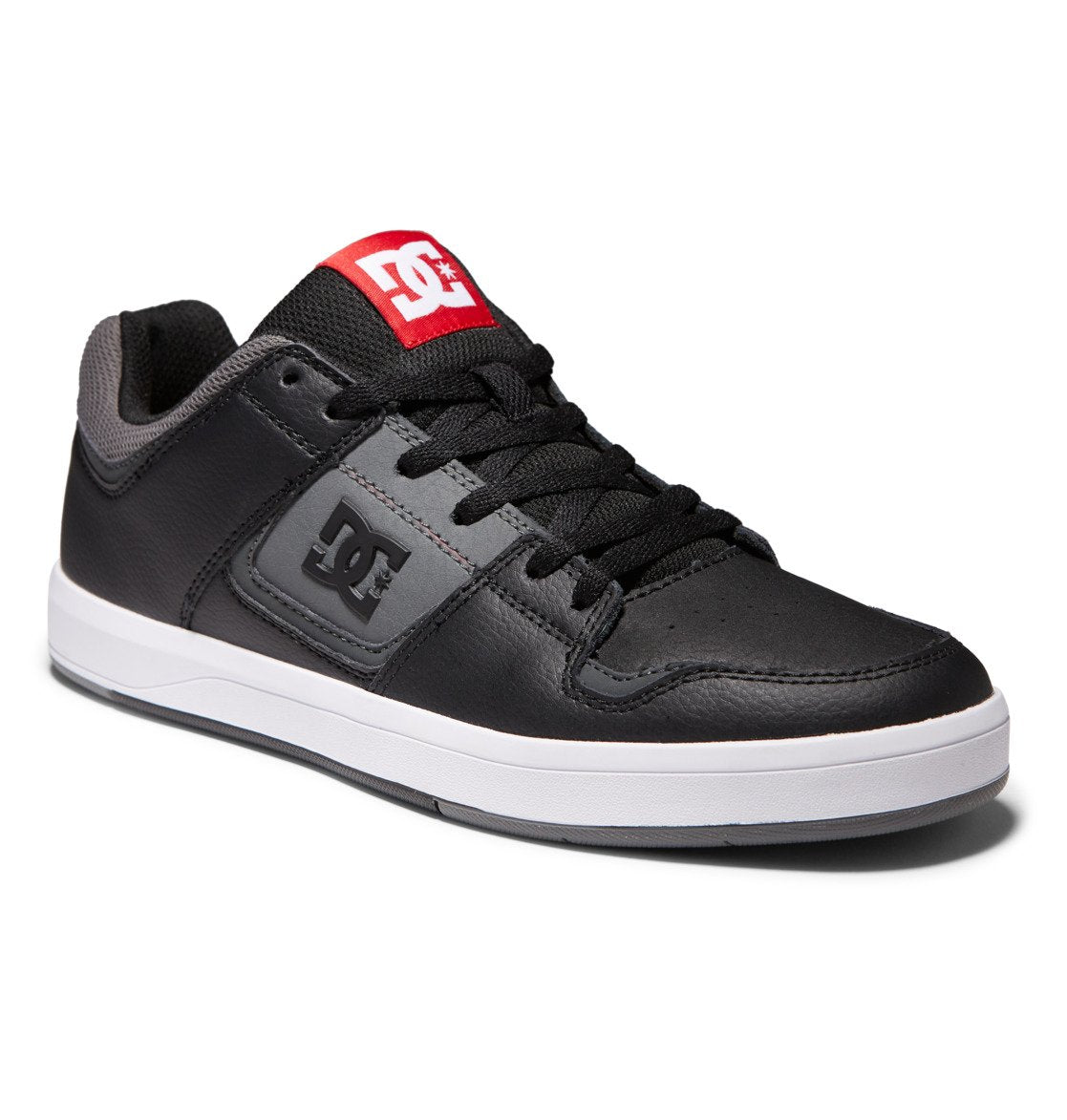 Men’s DC Cure Shoes by DC Shoes in black and gray, featuring a durable leather nubuck upper, white sole, and a red DC logo tag on the tongue. Shown from an angle highlighting the side, toe, and laces—these everyday shoes combine style with comfort.