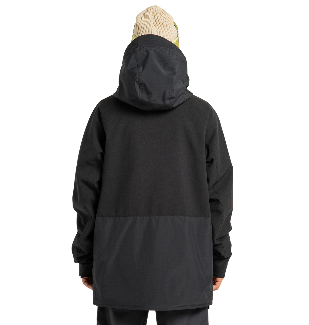 A person facing away, wearing the DC Shoes Men’s Tundra Insulated Jacket in two-tone black with a hood and a beige knit beanie, standing against a plain white background.