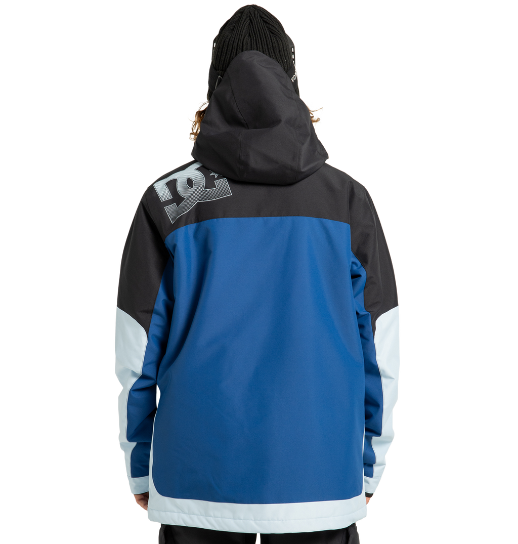 A person, seen from behind, wears the Men’s Defiant Insulated Jacket by DC Shoes—a hooded, insulated jacket in blue, black, and light blue recycled polyester with the DC Shoes logo on the upper back. The individual also has on a black beanie. The background is plain white.