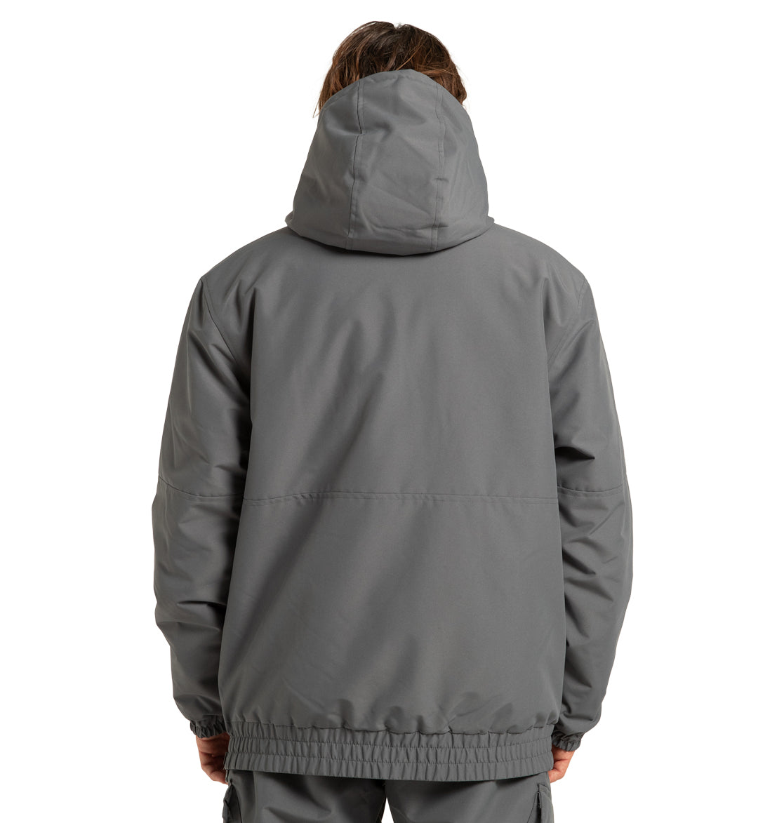 A person is shown from the back, facing away from the camera, wearing the DC Shoes Unisex Nexus Reversible Insulated Anorak Jacket in gray with the hood up and hands at their sides.