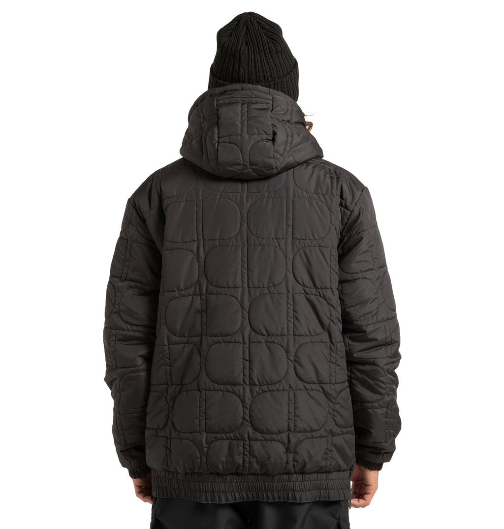 A person wearing the DC Shoes Unisex Nexus Reversible Insulated Anorak Jacket in black, featuring weather-resistant quilted construction and a hood, along with a black knit beanie, is seen from behind against a white background.