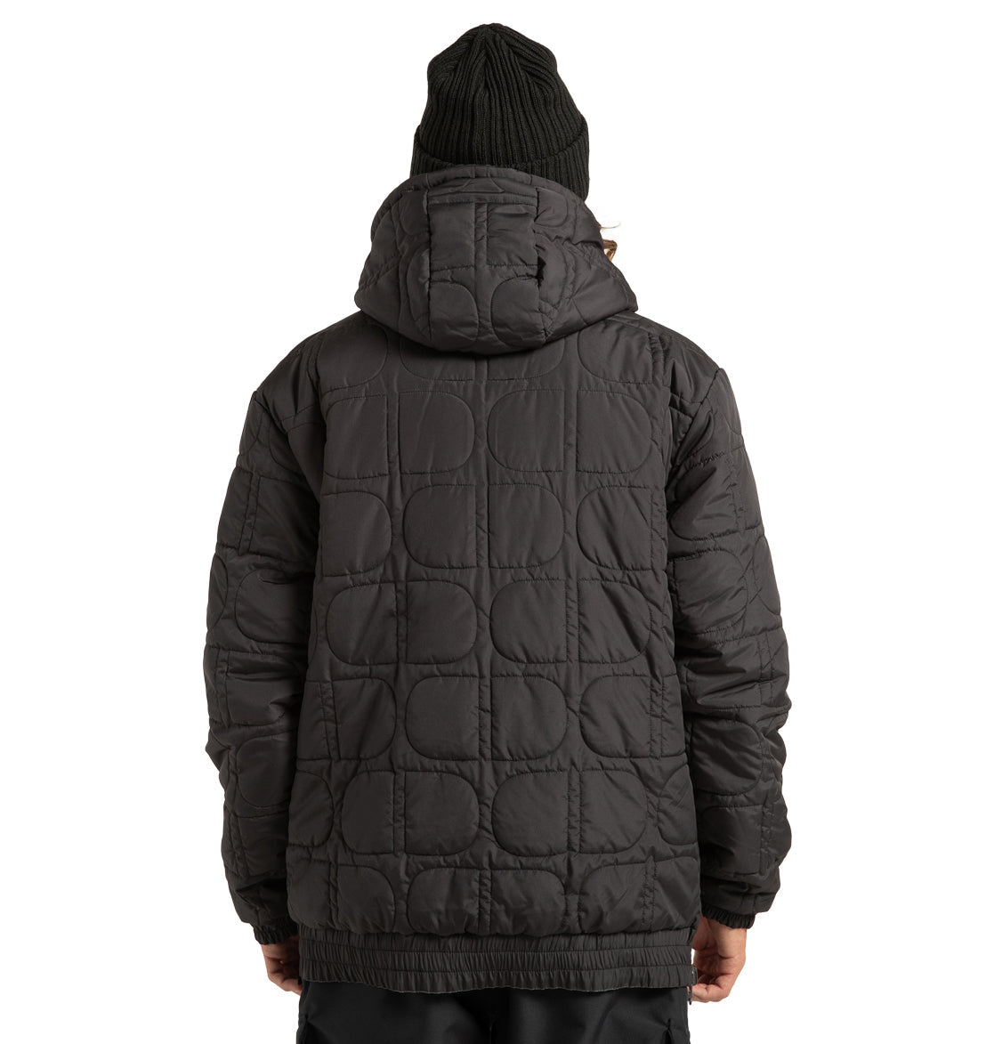 A person wearing the DC Shoes Unisex Nexus Reversible Insulated Anorak Jacket in black, featuring weather-resistant quilted construction and a hood, along with a black knit beanie, is seen from behind against a white background.