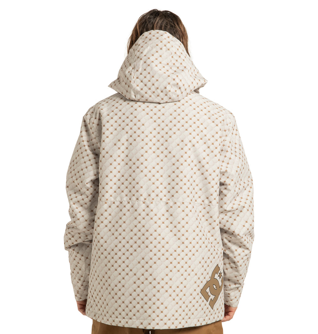 A person is seen from behind wearing the DC Shoes Unisex Basis Print Insulated Jacket, a hooded, patterned beige and white coat made from recycled polyester, featuring the DC logo on the lower right side near the hem.