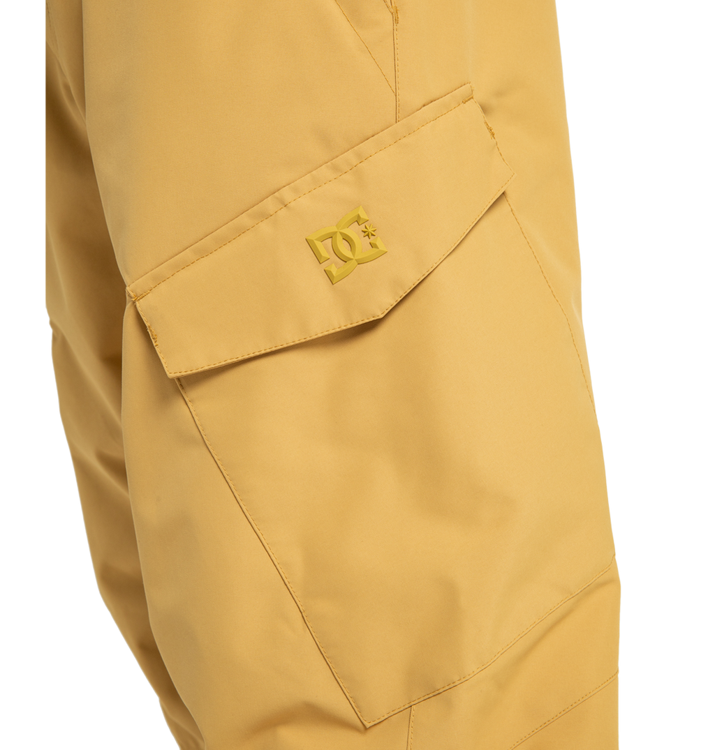Close-up of a mustard yellow cargo pocket on the Men’s Banshee Insulated Pants by DC Shoes, showcasing a flap with the embossed DC Shoes logo above the pocket. Made from recycled polyester, these men’s ski pants offer both style and functionality for your next adventure.