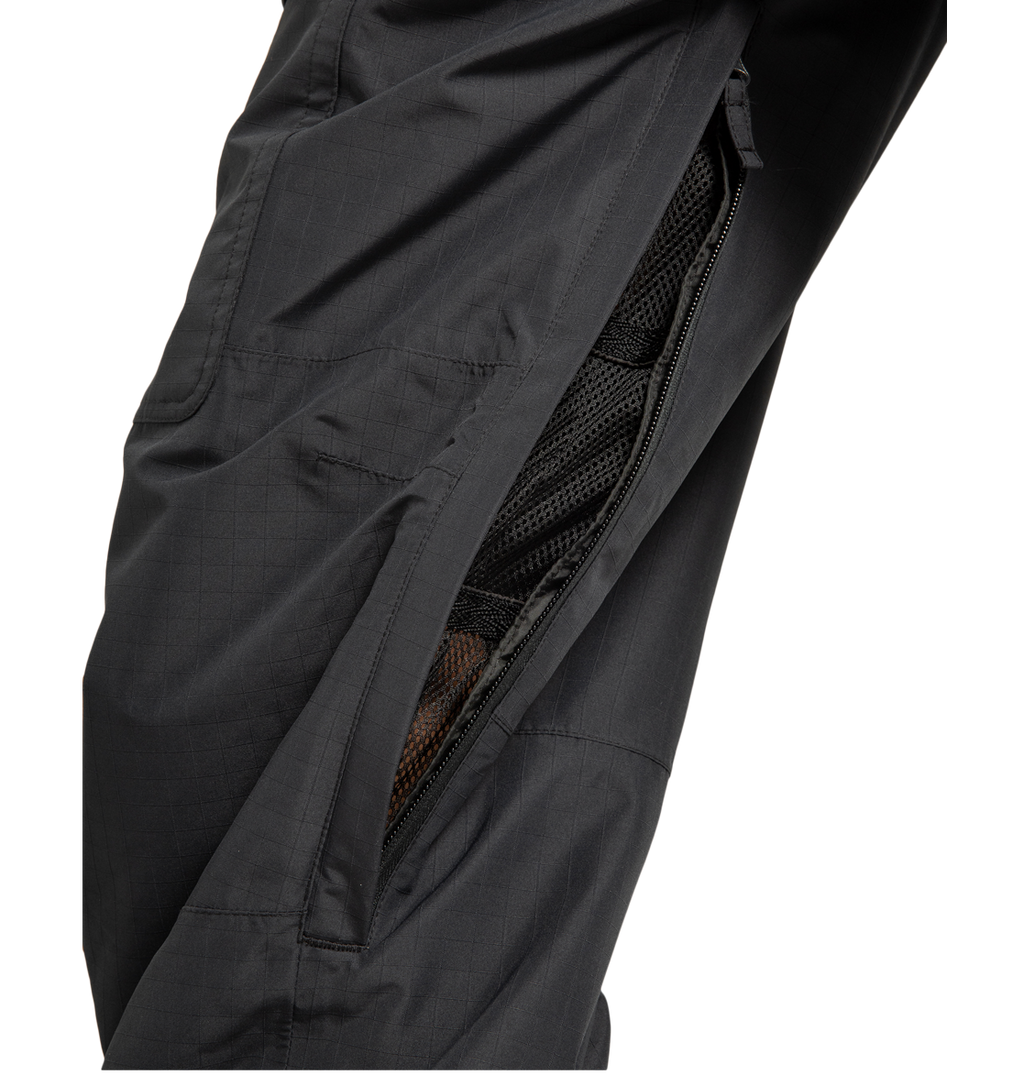Close-up of the DC Shoes Men’s Code Shell Pants in black, showcasing a partially unzipped side vent that reveals a mesh lining beneath. The fabric’s subtle grid pattern emphasizes the technical design and eco-friendly construction of these pants.