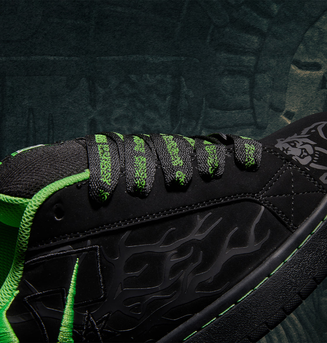 Black Men’s Court Graffik x Diablo skate shoe with bright green accents, patterned laces, and a flame-like graphic on the side.