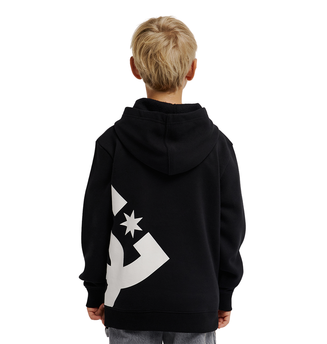 A young boy with blond hair, seen from behind, wears the DC Shoes Lanai Hoodie Youth in black with bold graphics on the back, standing against a plain white background.