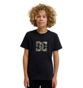 A young person with curly blond hair wears the DC Shoes DC Star Filled Tee Youth, a relaxed fit black graphic skate T-shirt featuring a camo-print DC Shoes star artwork logo on the chest, standing against a plain white background.