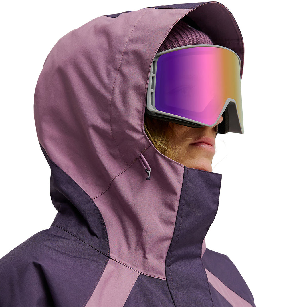 A person wearing a DC Shoes Everfrost Jacket in purple, paired with a beanie and reflective ski goggles, is shown facing sideways.