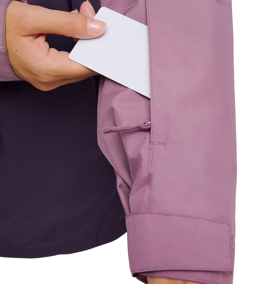 A person slides a white card into the zippered sleeve pocket of the light purple Everfrost Jacket by DC Shoes.