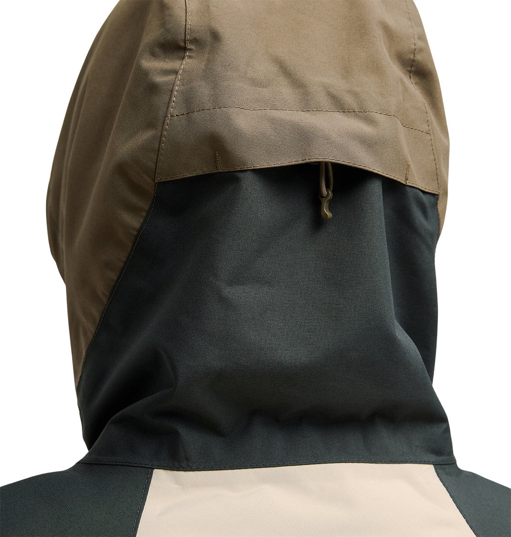 Close-up of the back of the DC Shoes Everfrost Jacket, a hooded insulated design in tan, dark green, and beige, highlighting the stitching detail and small hanging loop on the hood.