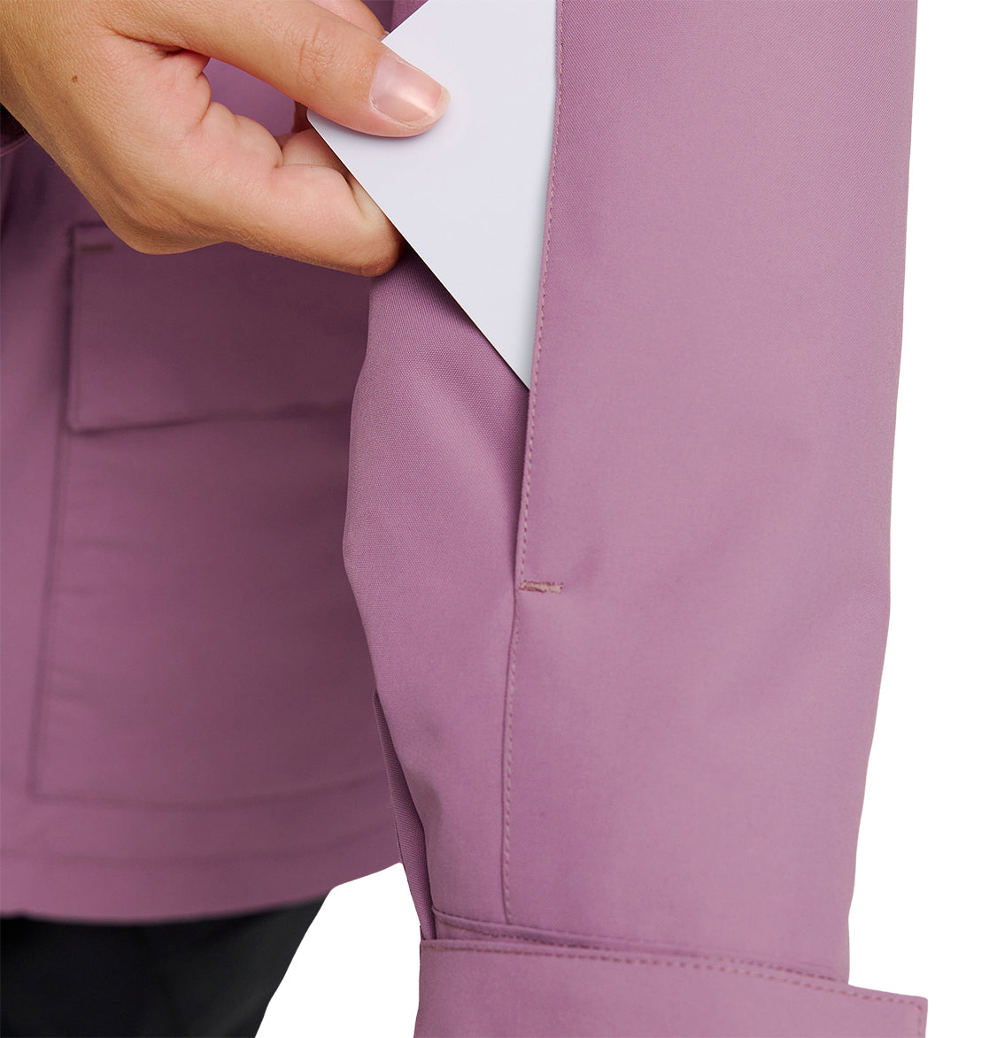A hand inserts a white card into the chest pocket of a mauve DC Shoes Cruiser Jacket.