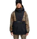 A person wearing ski goggles and a black DC Shoes Chalet Anorak with leopard print sleeves and matching pants stands facing forward against a white background. This outfit provides breathable protection and waterproofing, delivering ultimate comfort in any condition.