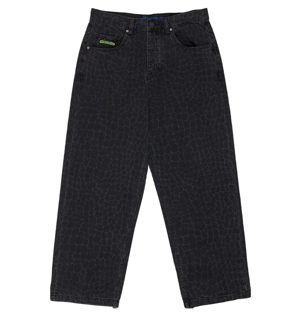 The DC Shoes Men's Baggy Denim Snake Print Pant features a subtle laser reptile-skin pattern, five pockets, a green label on one front pocket, and a baggy fit. Shown laid flat on a white background.