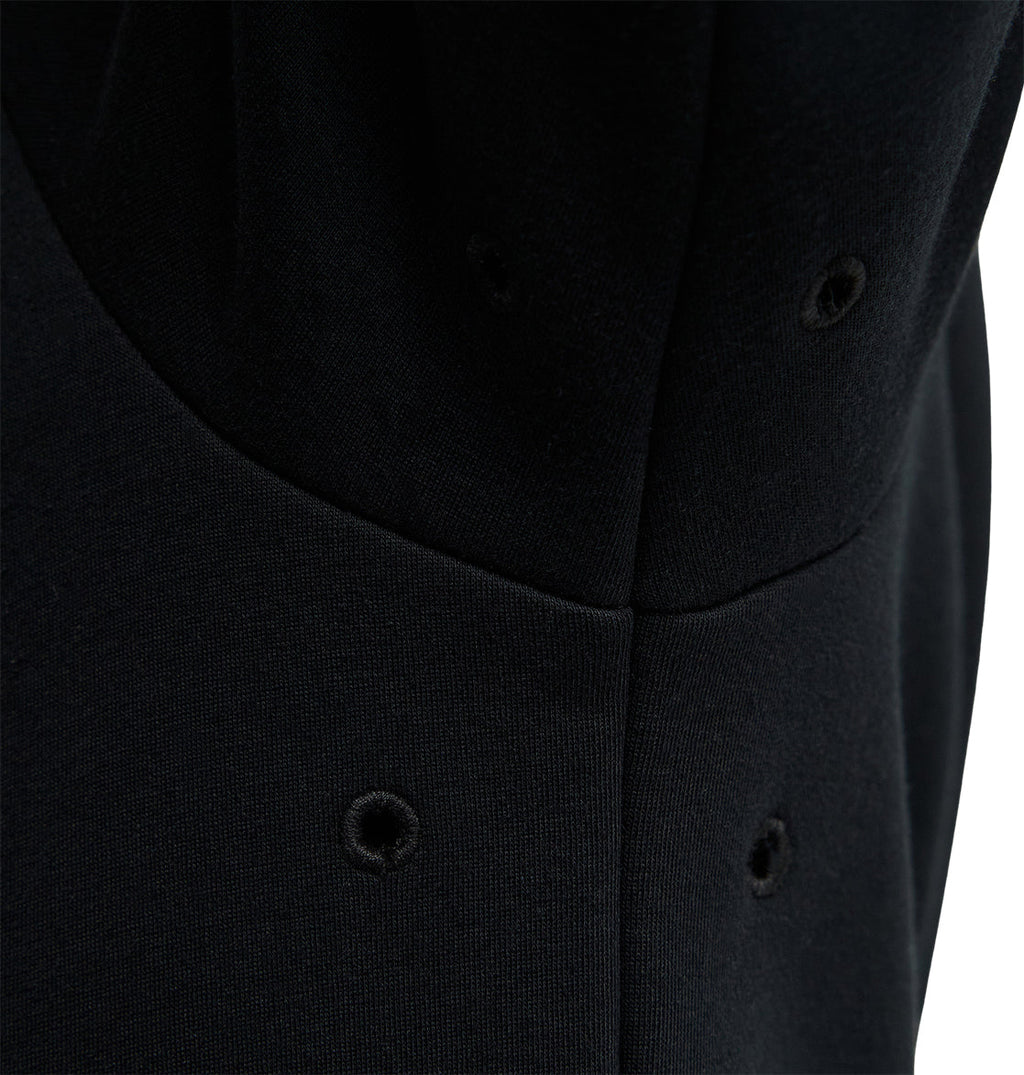 Close-up of a black fabric with stitched eyelet holes arranged in pairs, showing seam lines and subtle texture on the material—crafted for reliable snow-day performance and comfortable fit in the DC Shoes Snowstar.
