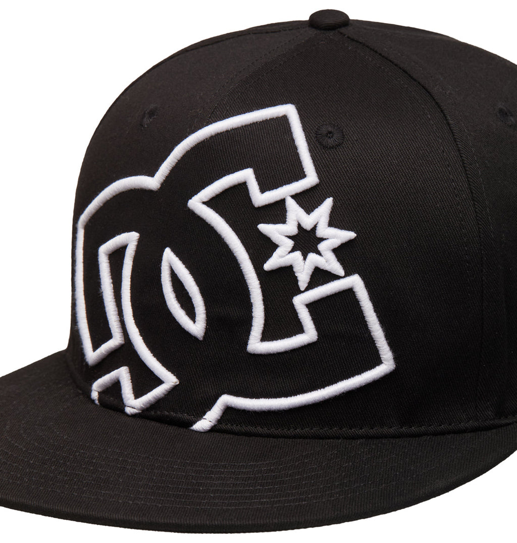The Reebok DC Double That Cap is a black flat-brim baseball cap featuring a large white embroidered DC Shoes logo with a star on the front panel.
